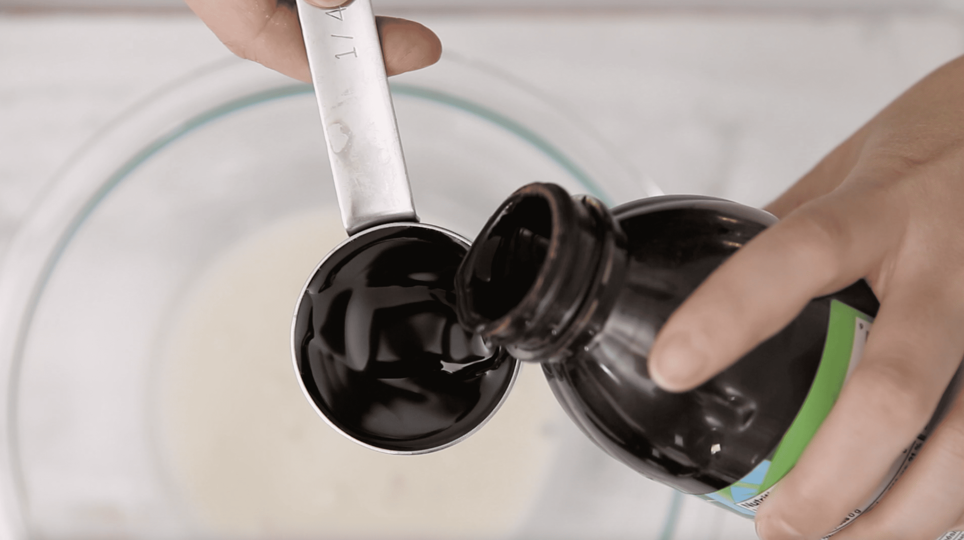 molasses being added to a mixing bowl