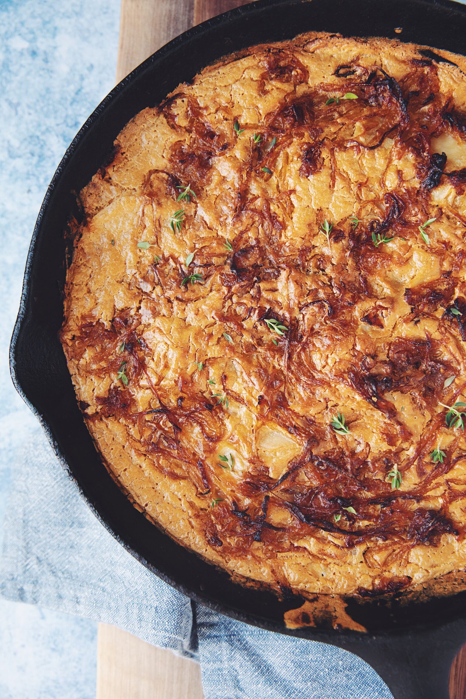 top down of vegan scalloped potatoes with caramelized onions in a skillet