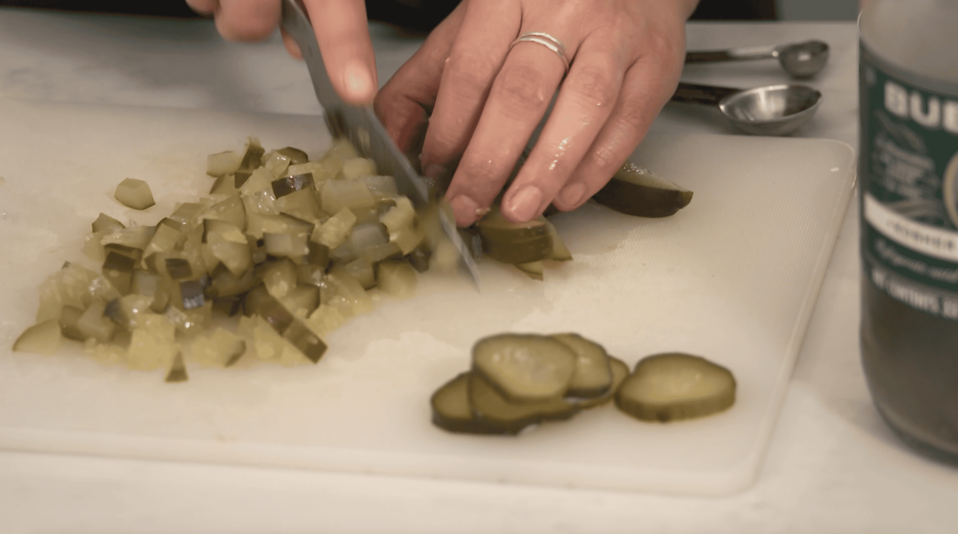 pickles being chopped on a cutting board