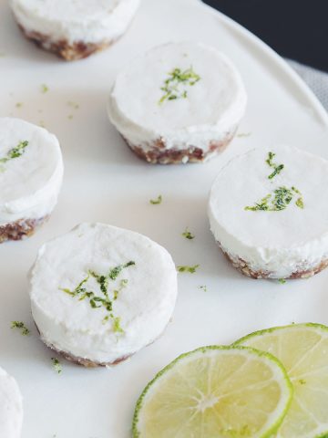a plate of mini vegan cheesecake bites garnished with lime slices