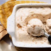 overhead of pineapple ginger snap ice cream in a baking dish with a ice cream scoop and cones