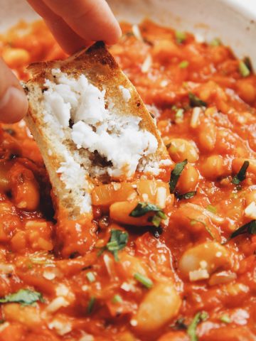 cheesy harissa beans served with toasted sourdough and vegan cheese