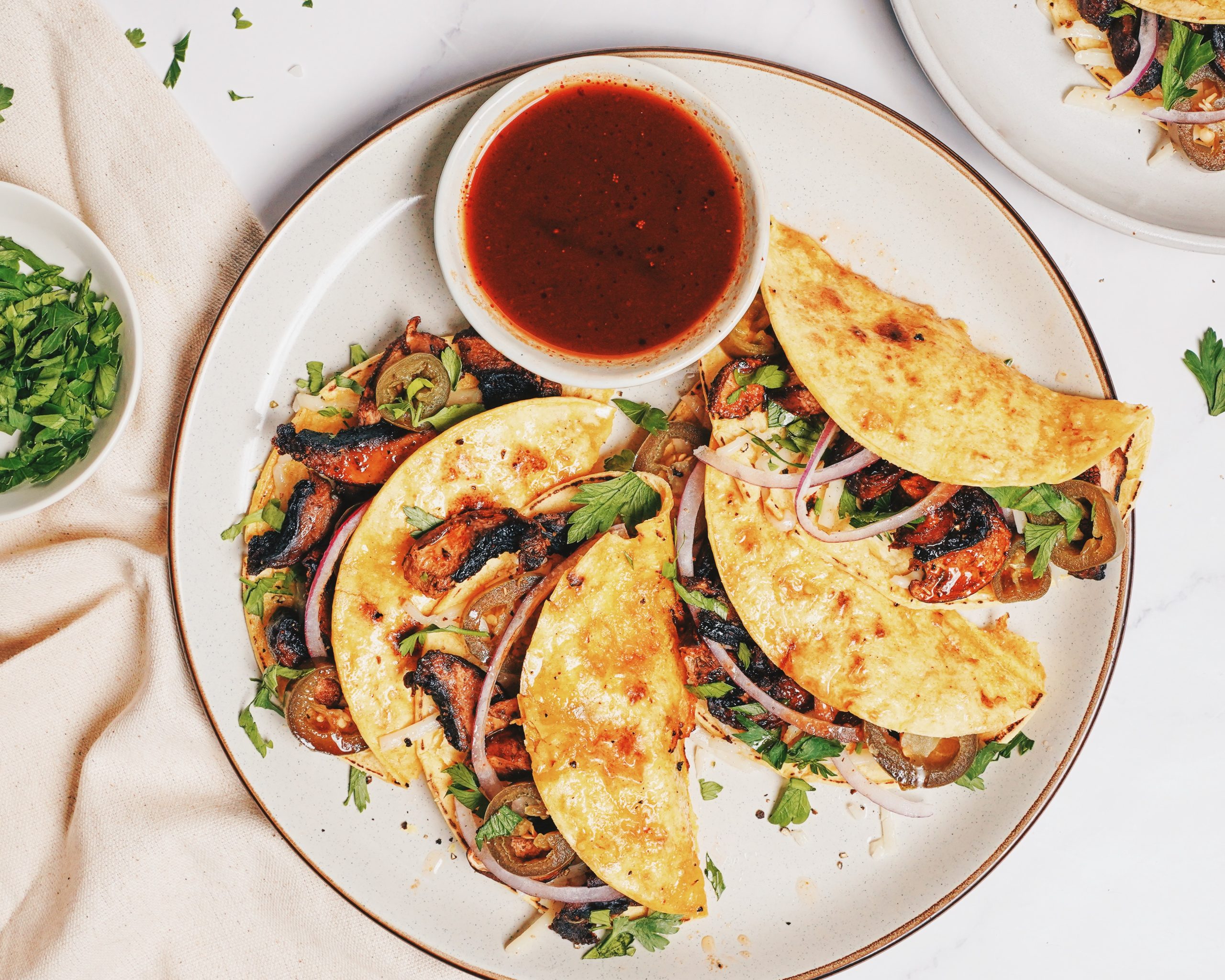 close up of mushroom birria taco garnished with cilantro and sliced red onion