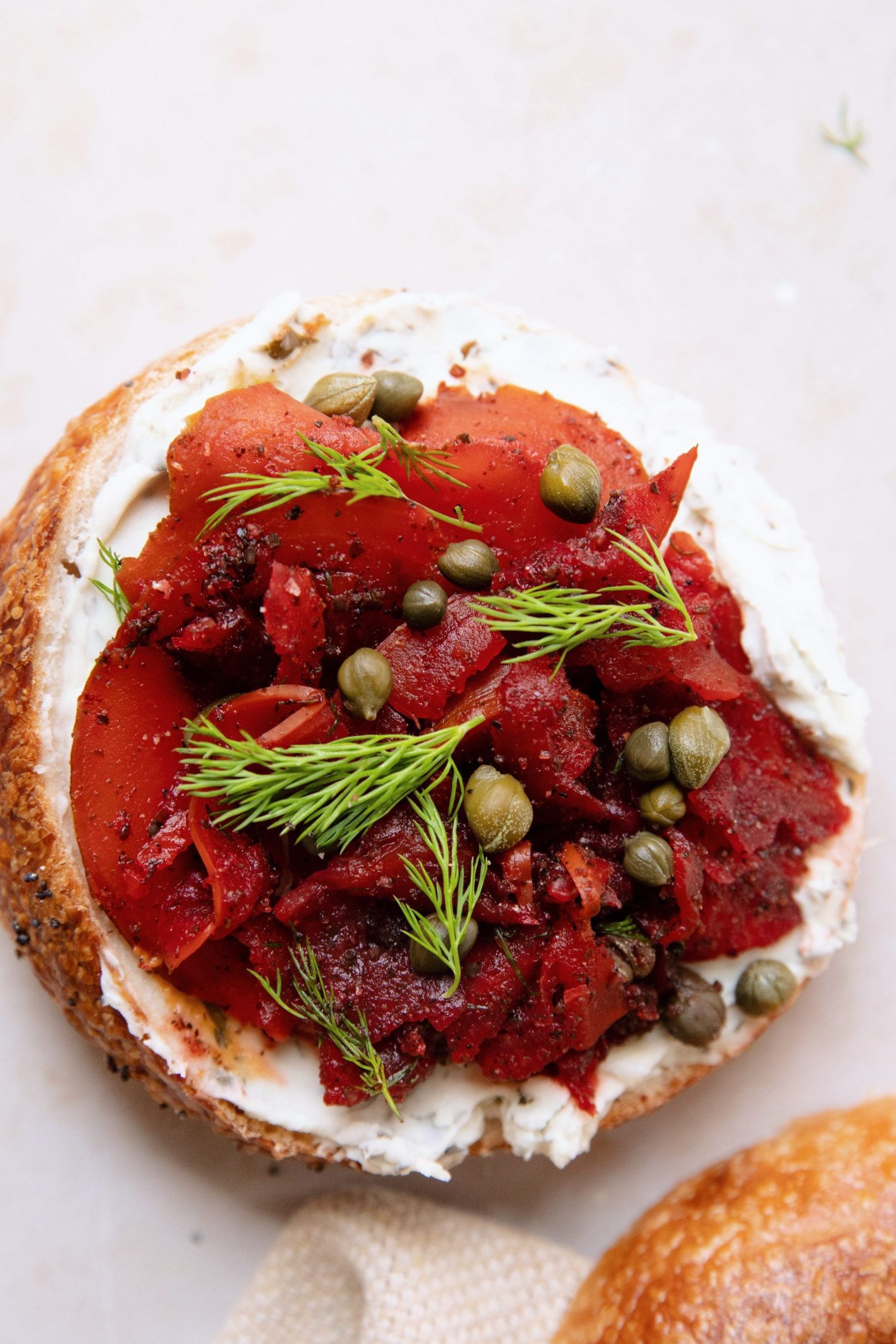 sliced beet lox on a bagel with vegan cream cheese and dill