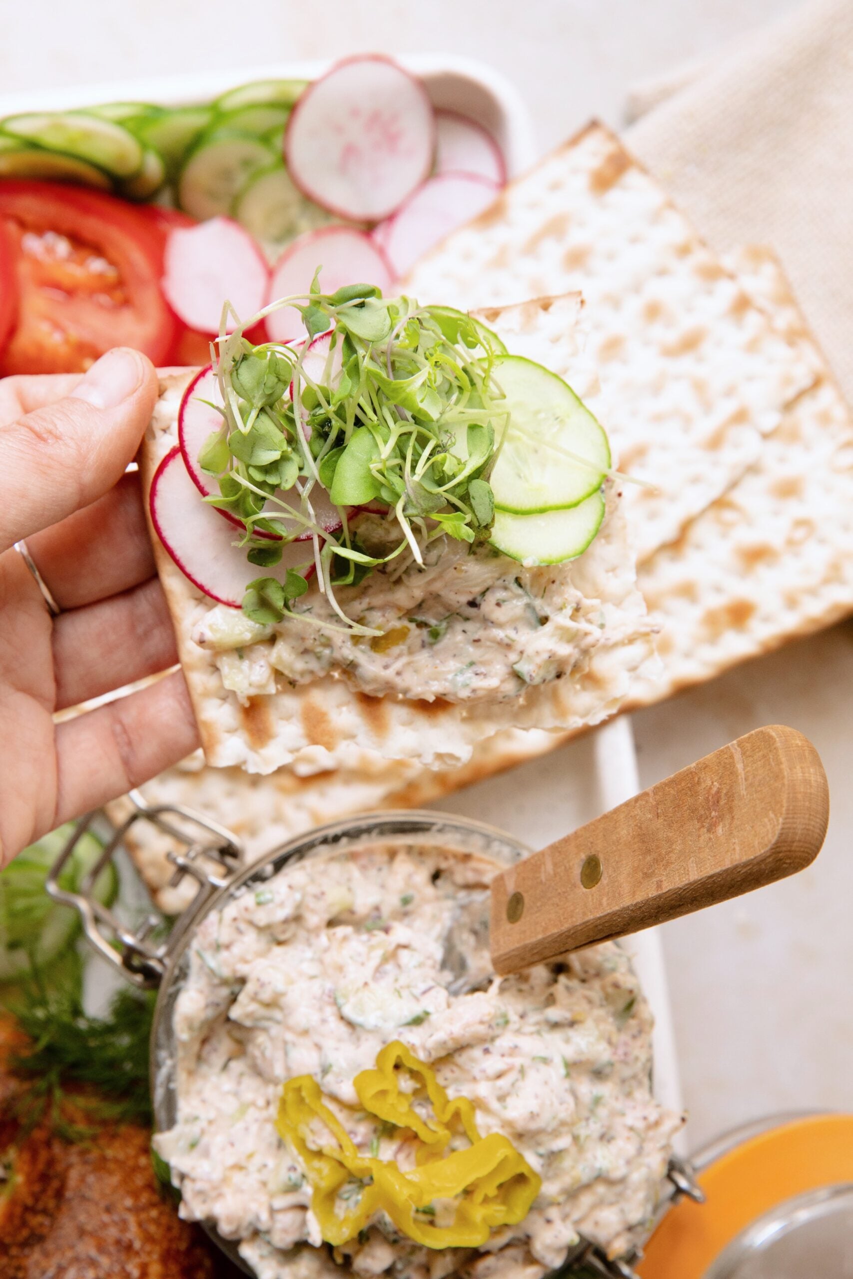 vegan white fish spread on a cracker with vegetable toppings